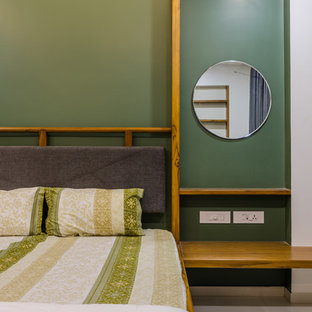 Immagine di una camera da letto etnica con pareti verdi e pavimento grigio