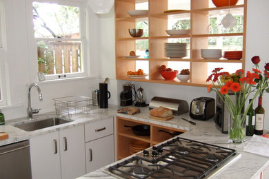 Example of a small transitional u-shaped kitchen design in Seattle with an undermount sink, flat-panel cabinets, white cabinets, marble countertops, white backsplash and no island