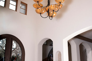 Photo of a large mediterranean foyer in San Francisco with white walls, dark hardwood floors, a double front door and a dark wood front door.