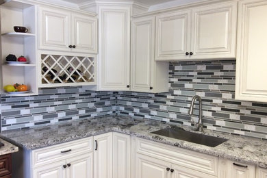 Inspiration for a large timeless kitchen remodel in Los Angeles with an undermount sink, raised-panel cabinets, white cabinets, granite countertops, multicolored backsplash and matchstick tile backsplash