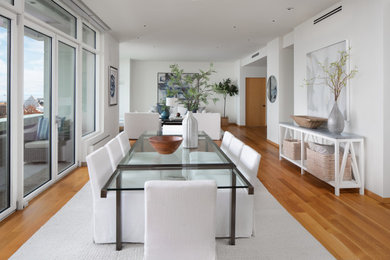 Example of a trendy medium tone wood floor and brown floor great room design in Milwaukee with white walls and no fireplace