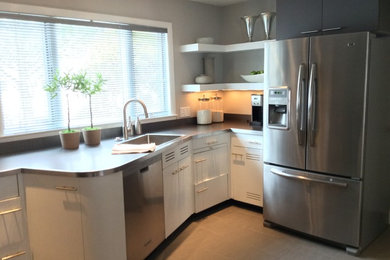 Eat-in kitchen - mid-sized contemporary l-shaped ceramic tile eat-in kitchen idea in Boston with a drop-in sink, stainless steel appliances, flat-panel cabinets, beige cabinets, laminate countertops, gray backsplash and no island
