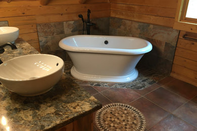 Mid-sized mountain style master stone tile mosaic tile floor, double-sink and wood wall freestanding bathtub photo in Denver with a vessel sink, quartzite countertops and a built-in vanity