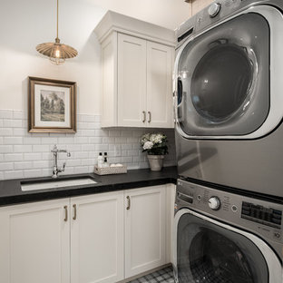 Country l-shaped separated utility room in Salt Lake City with a submerged sink, shaker cabinets, white cabinets, white walls, a side by side washer and dryer, multi-coloured floors and black worktops.