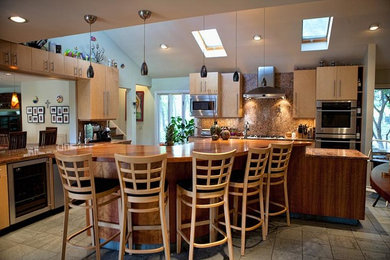 Design ideas for a large transitional l-shaped kitchen in Austin with an undermount sink, flat-panel cabinets, light wood cabinets, granite benchtops, stone slab splashback, stainless steel appliances, with island and multi-coloured benchtop.