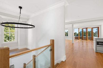 Large transitional medium tone wood floor and brown floor hallway photo in Boston with white walls