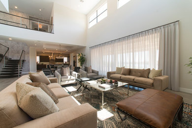 Large contemporary loft-style living room in Las Vegas with white walls and light hardwood floors.