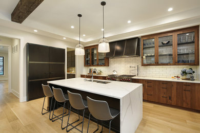 Large minimalist l-shaped light wood floor and beige floor open concept kitchen photo in Chicago with an undermount sink, flat-panel cabinets, medium tone wood cabinets, quartzite countertops, white backsplash, subway tile backsplash, paneled appliances, an island and white countertops