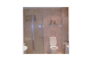 This is an example of a mid-sized contemporary bathroom in Central Coast with white cabinets, a corner shower, beige walls, marble floors, a wall-mount sink, beige floor and a hinged shower door.