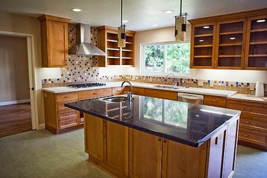 Example of a mid-sized classic l-shaped enclosed kitchen design in Boston with an undermount sink, recessed-panel cabinets, light wood cabinets, quartz countertops, multicolored backsplash, ceramic backsplash, stainless steel appliances and an island