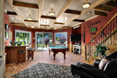 Photo of a large traditional enclosed family room in San Diego with a home bar, red walls, brick floors, no fireplace, a freestanding tv and brown floor.
