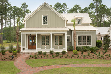 This is an example of a mid-sized traditional two-storey green house exterior in Charleston with wood siding and a metal roof.