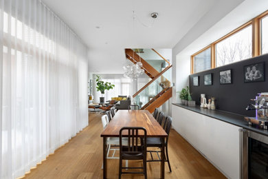 Inspiration for a mid-sized modern medium tone wood floor and brown floor kitchen/dining room combo remodel in Ottawa with white walls and no fireplace