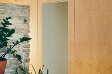Mid-century modern wall paneling entryway photo in Austin