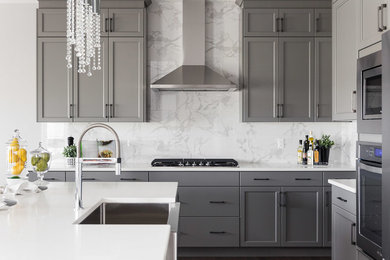 Mid-sized transitional galley dark wood floor and brown floor eat-in kitchen photo in Edmonton with a farmhouse sink, recessed-panel cabinets, gray cabinets, quartzite countertops, white backsplash, marble backsplash, stainless steel appliances and an island
