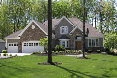 Example of a large classic gray two-story wood exterior home design in Cleveland with a shingle roof