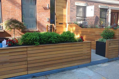 Photo of a mid-sized modern backyard deck in New York with a container garden and no cover.