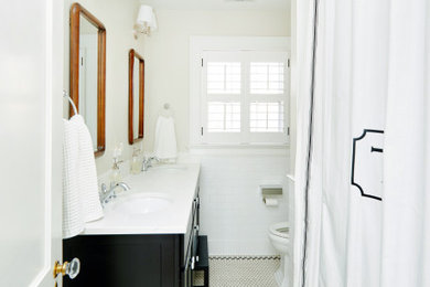 Bathroom - craftsman white tile and ceramic tile ceramic tile, white floor and double-sink bathroom idea in Kansas City with flat-panel cabinets, black cabinets, a two-piece toilet, white walls, an undermount sink, quartz countertops, white countertops and a freestanding vanity