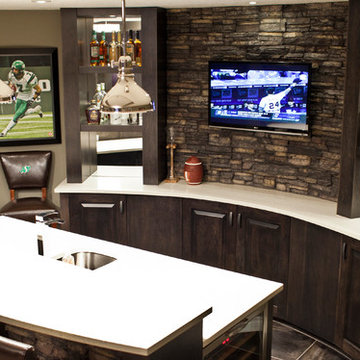 Stone basement wetbar and dark wood cabinetry