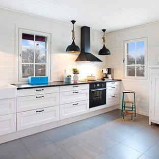 Idee per una grande cucina lineare nordica con lavello stile country, ante con riquadro incassato, ante bianche, paraspruzzi bianco e elettrodomestici neri