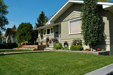 Photo of a large traditional full sun front yard stone retaining wall landscape in Calgary for spring.
