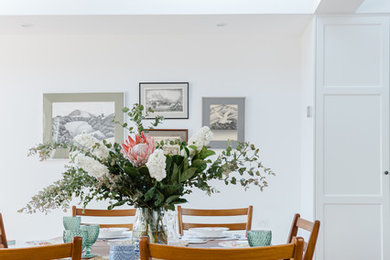 Inspiration for a mid-sized traditional kitchen/dining combo in Melbourne with white walls and light hardwood floors.