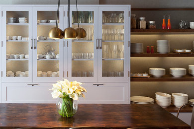 Eclectic brick floor kitchen photo in New York with glass-front cabinets