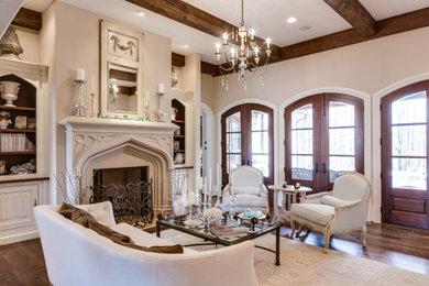 Living room - large french country open concept medium tone wood floor and exposed beam living room idea in Atlanta with beige walls and a standard fireplace