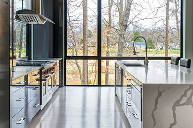 Example of a trendy galley white floor kitchen design in Other with an undermount sink, flat-panel cabinets, gray cabinets, window backsplash, stainless steel appliances, an island and white countertops