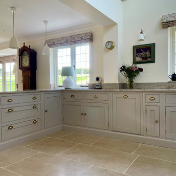Light grey traditional handmade kitchen with glazed bar wall cabinets and mantel