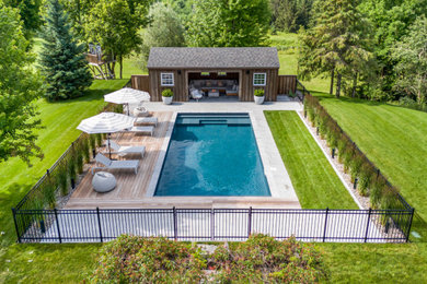 Example of a large mountain style backyard rectangular pool design in Ottawa