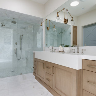 Cette image montre une salle de bain principale rustique avec des portes de placard en bois clair, une douche double, un lavabo encastré, une cabine de douche à porte battante, un plan de toilette en quartz, un plan de toilette blanc, des carreaux de miroir, un mur beige, un sol en marbre et un sol blanc.