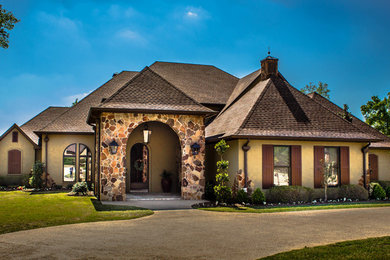 Example of a classic brown two-story stucco exterior home design in Other