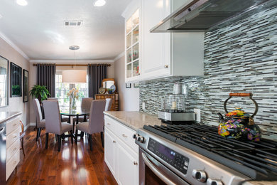Inspiration for a small traditional galley eat-in kitchen in Sacramento with recessed-panel cabinets, white cabinets, granite benchtops, multi-coloured splashback, matchstick tile splashback, stainless steel appliances, medium hardwood floors and no island.