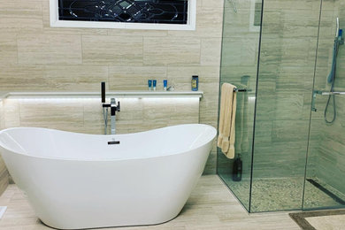 Large minimalist master beige tile wood-look tile floor and vaulted ceiling bathroom photo in Charlotte with beige walls and a hinged shower door