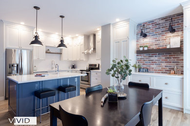 Example of a large urban l-shaped porcelain tile and gray floor kitchen design in Calgary with an undermount sink, shaker cabinets, white cabinets, quartz countertops, white backsplash, subway tile backsplash, stainless steel appliances, an island and white countertops