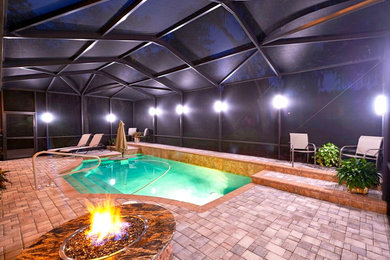 Inspiration for a contemporary backyard brick pool remodel in Tampa