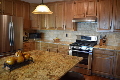 Mid-sized mountain style u-shaped porcelain tile and brown floor eat-in kitchen photo in New York with an undermount sink, raised-panel cabinets, medium tone wood cabinets, granite countertops, beige backsplash, travertine backsplash, stainless steel appliances and an island