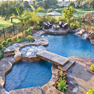 オレンジカウンティの大きいオーダーメイドトロピカルスタイルのおしゃれなプール (天然石敷き) の写真