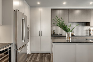 Inspiration for a mid-sized modern dark wood floor and gray floor eat-in kitchen remodel in Calgary with an undermount sink, flat-panel cabinets, gray cabinets, granite countertops, gray backsplash, ceramic backsplash, stainless steel appliances, an island and gray countertops