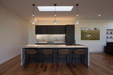 Photo of a large contemporary single-wall open plan kitchen in Melbourne with flat-panel cabinets, brown cabinets, marble benchtops, grey splashback, marble splashback, stainless steel appliances, light hardwood floors, with island, brown floor and grey benchtop.
