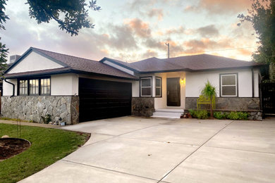 Example of a small mountain style white one-story stucco house exterior design in Los Angeles with a shingle roof and a brown roof
