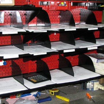Red metal pegboard being used to create a pick station for paperwork with the us
