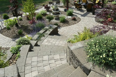 Design ideas for a mid-sized traditional drought-tolerant backyard concrete paver retaining wall landscape in Vancouver.