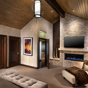 Mittelgroßes Modernes Hauptschlafzimmer mit grauer Wandfarbe, Teppichboden, Gaskamin, Kaminumrandung aus Stein und beigem Boden in Denver