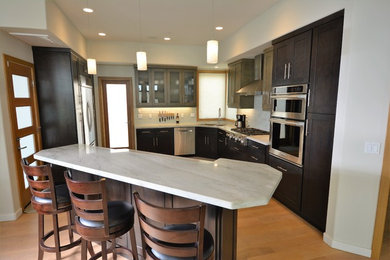 Kitchen - large transitional u-shaped medium tone wood floor and brown floor kitchen idea in San Diego with an undermount sink, shaker cabinets, dark wood cabinets, white backsplash, stainless steel appliances, an island, quartz countertops and subway tile backsplash