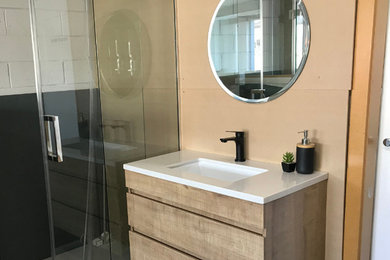 This is an example of a modern bathroom in Melbourne with marble benchtops.