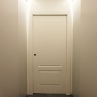 Réalisation d'une petit buanderie parallèle sud-ouest américain multi-usage avec un placard à porte plane, des portes de placard grises, un mur gris, un sol en carrelage de porcelaine, des machines superposées, un sol gris et un plafond décaissé.