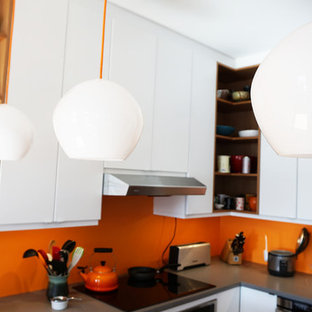 Idéer för stora funkis kök, med släta luckor, vita skåp, orange stänkskydd och rostfria vitvaror