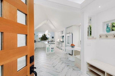 Open concept kitchen - mid-sized transitional u-shaped ceramic tile and white floor open concept kitchen idea in Seattle with a farmhouse sink, shaker cabinets, white cabinets, white backsplash, white appliances, an island and black countertops